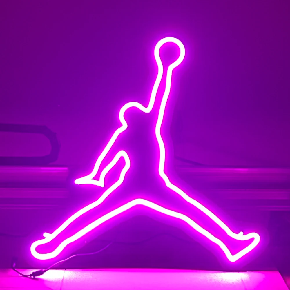 The same Jumpman sign finished and lit in pink neon on the workshop bench